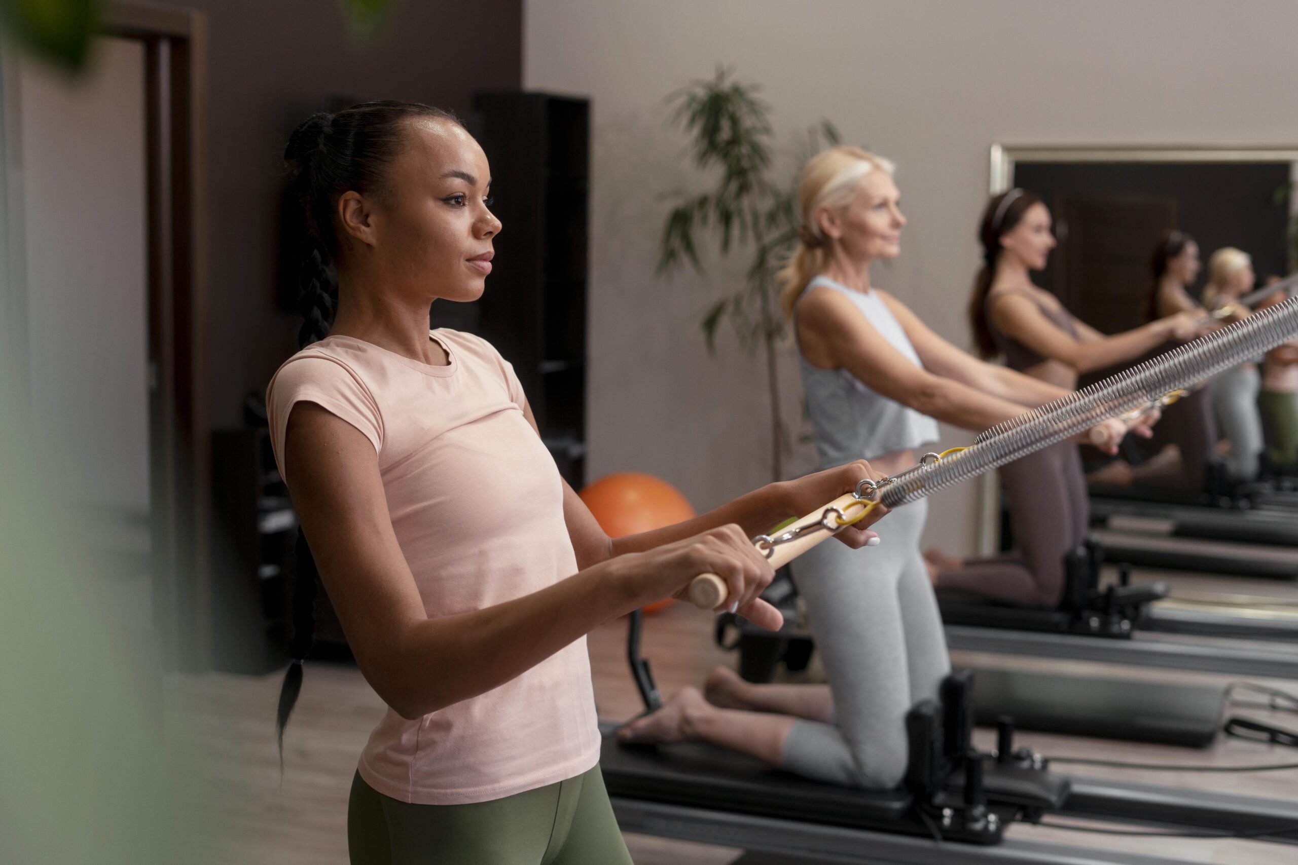 people-pilates-reformer-class-exercising-their-bodies-min